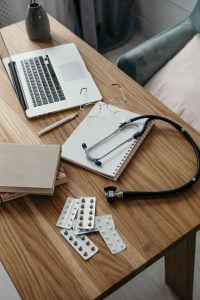 A GP's desk with a laptop, notebook and stethoscope after a missed GP appraisal deadline
