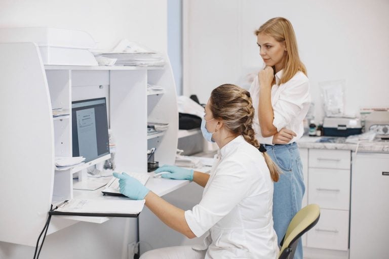 Quality improvement activity: two clinicians reviewing practice data on a computer screen